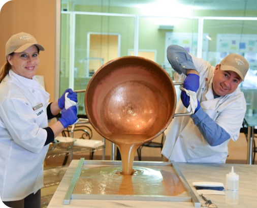 Kilwins workers pouring candy mixture